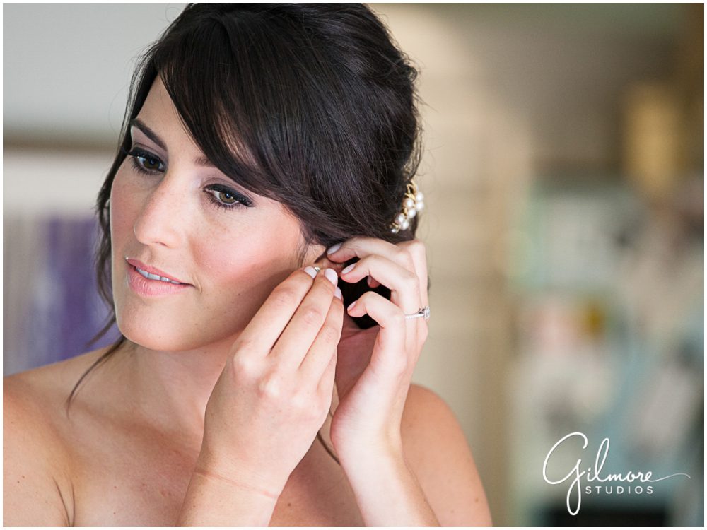 bride putting earings on - getting ready for wedding