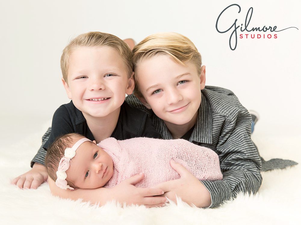 big brothers holding their brand new baby sister