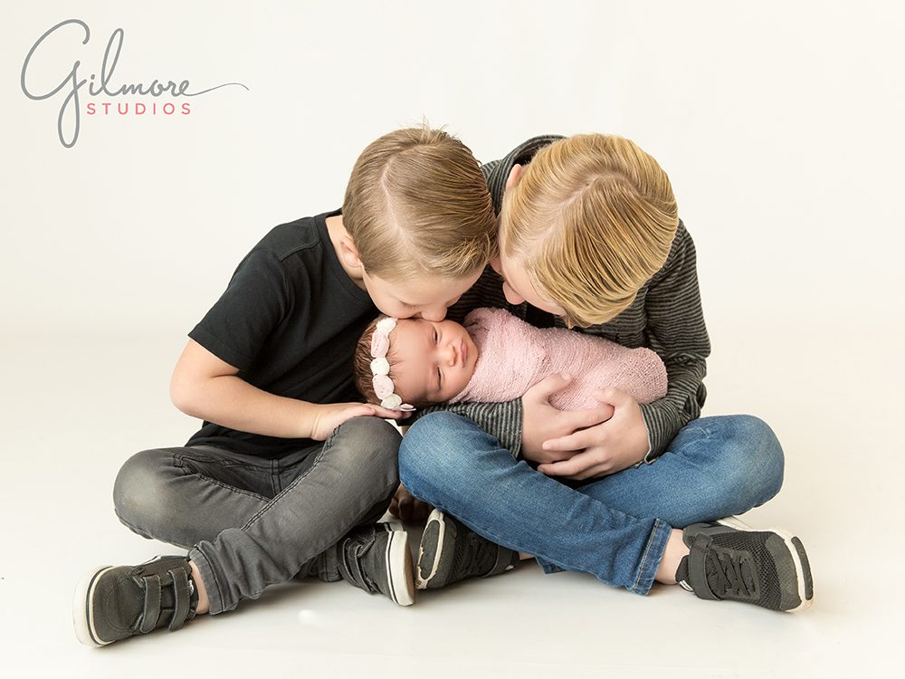 Newborn family photographer - big brothers holding baby