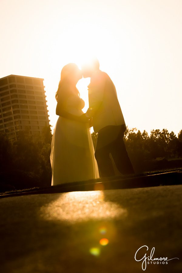 wedding couple kissing in front of the sunset