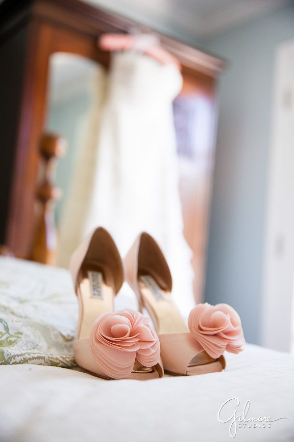 Blush Badgley Mischka wedding shoes with dress in the background