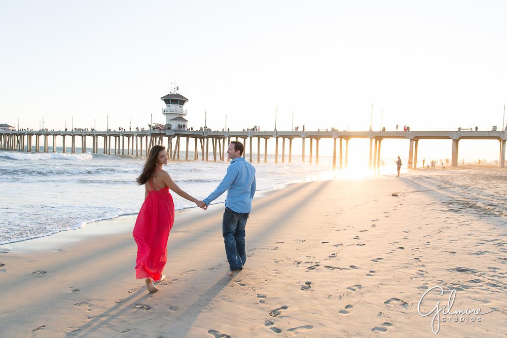 engaged couple walking on the shores of HB