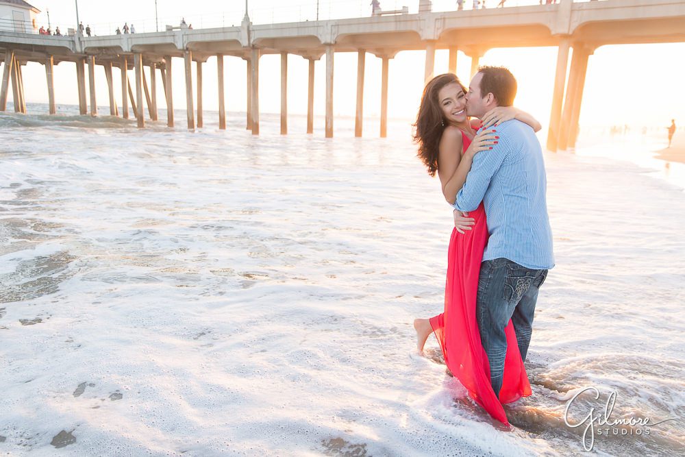 Engaged and wading in the waves of Huntington Beach, CA