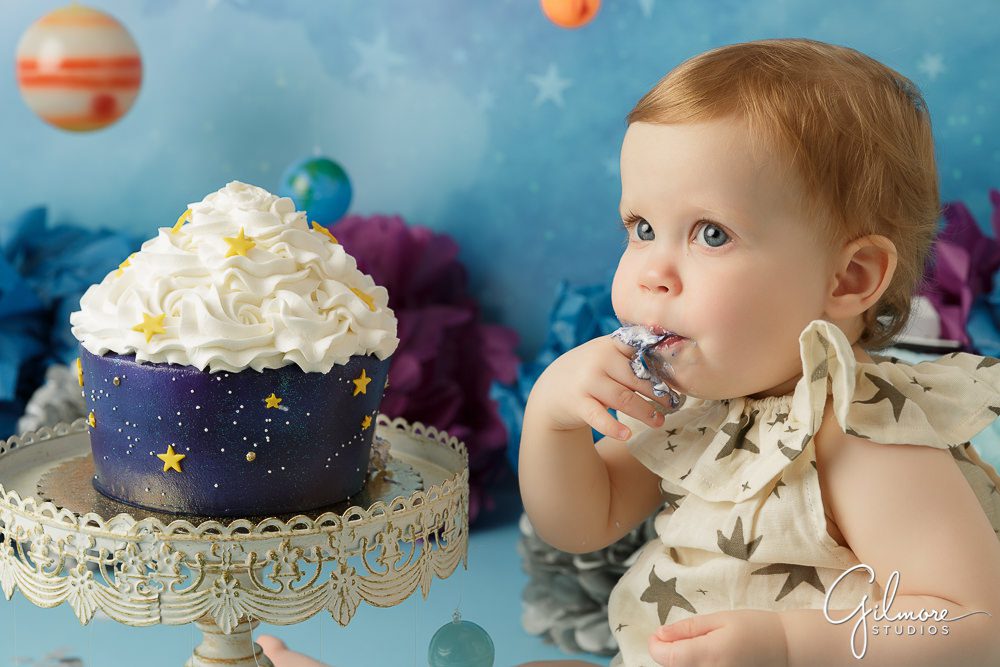 one year old eating her outer space birthday cake