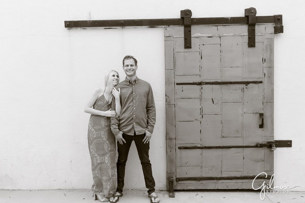 Couple stands by a vintage door in Balboa