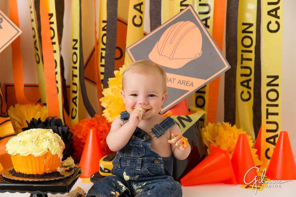 Setting up the traffic cones, caution tape, and toy trucks. Cake Smash session photography