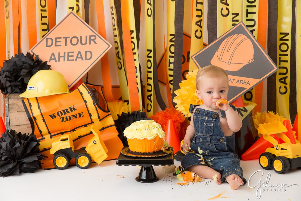 One year old eating cake at his construction themed cake smash