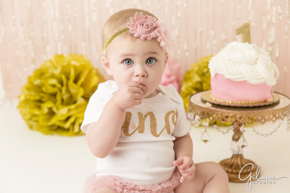 baby girl eating cake for her first birthday