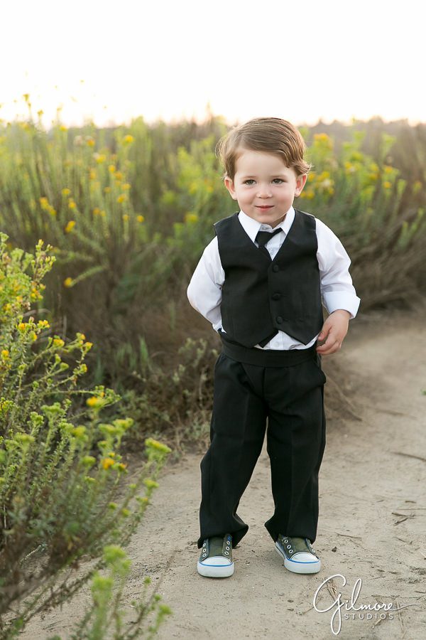 boy standing on the trail with black tie and vest