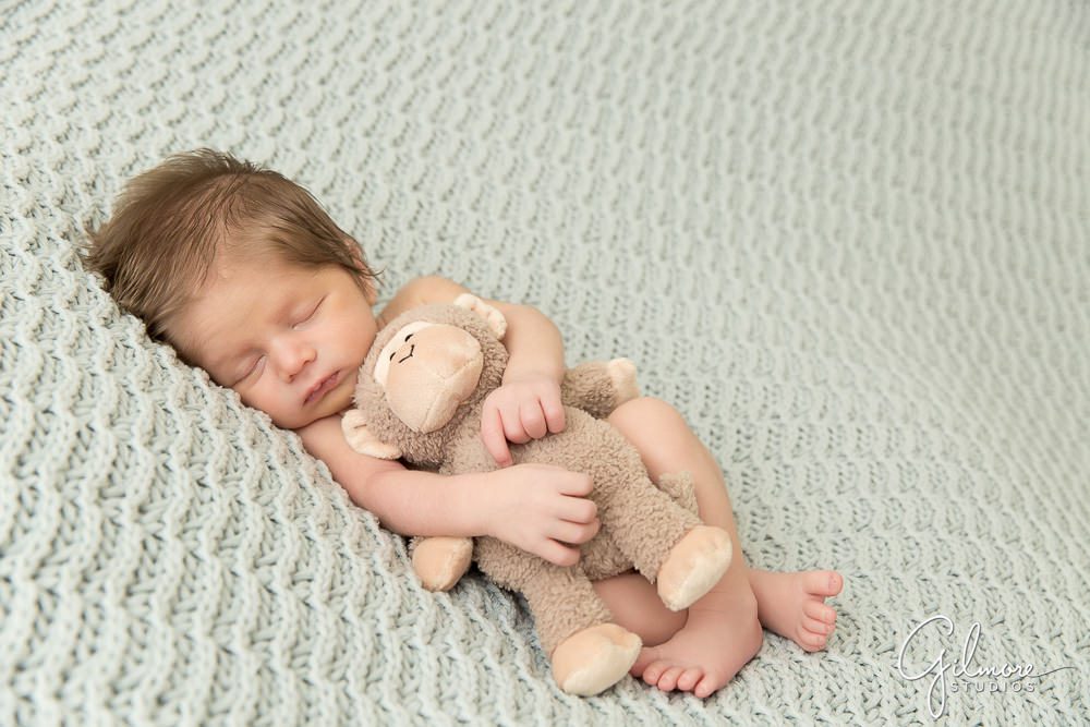 baby boy sleeping with his stuffed animal toy bear