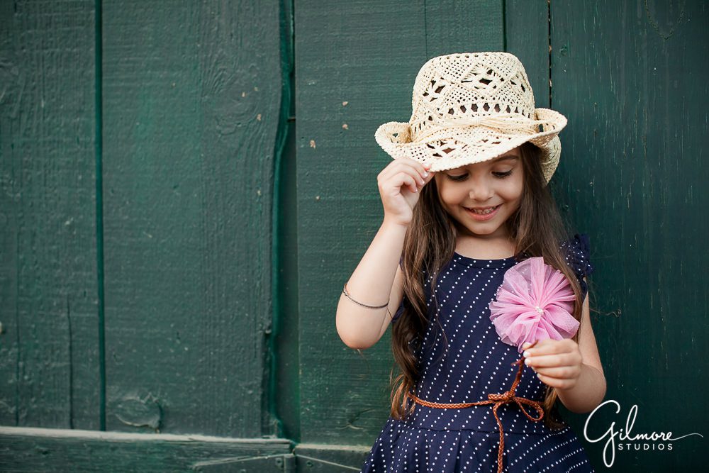 little girl wears a cute straw hat, Crystal Cove family photographer