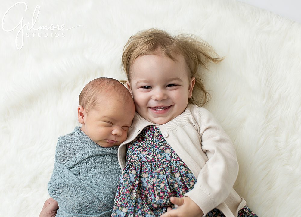 sweet baby brother lays with his sister, Newport Coast Newborn Photographer