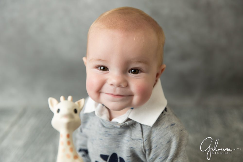 6 month old boy holding a Sophie the Giraffe Teether