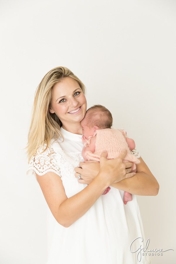 mother holding her brand new baby girl at our Orange County newborn studio