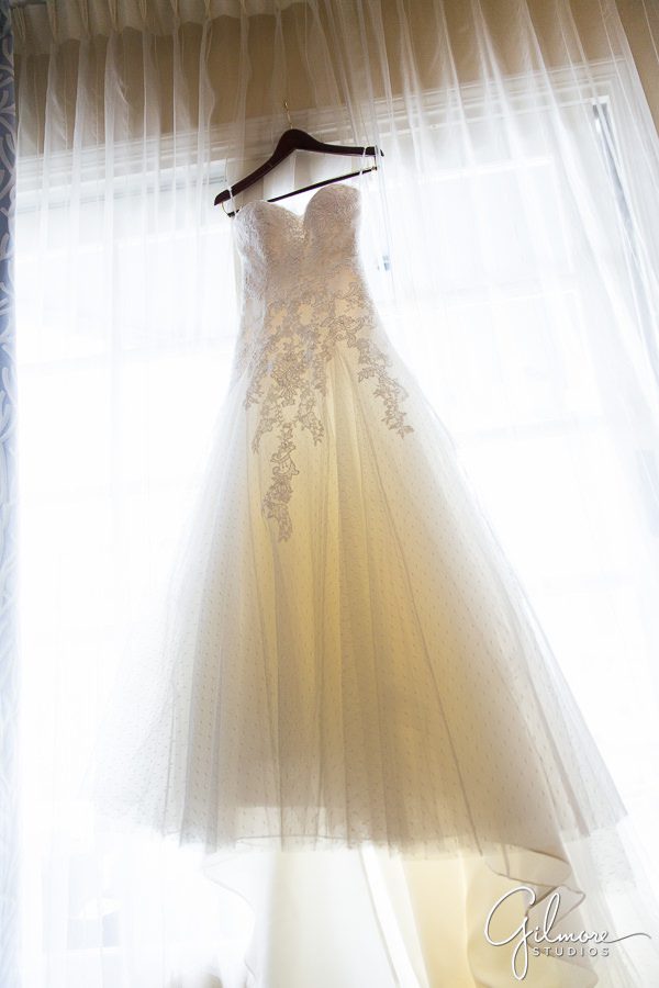 wedding dress hangs in the window before the bride arrives