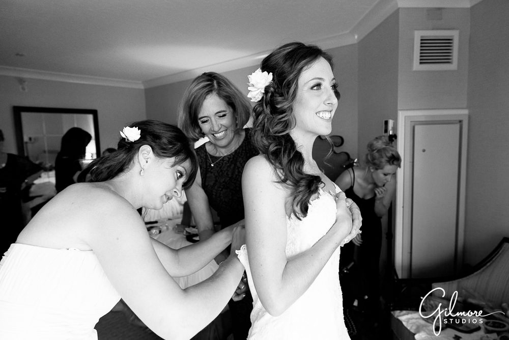 bridesmaids helping the bride get dressed