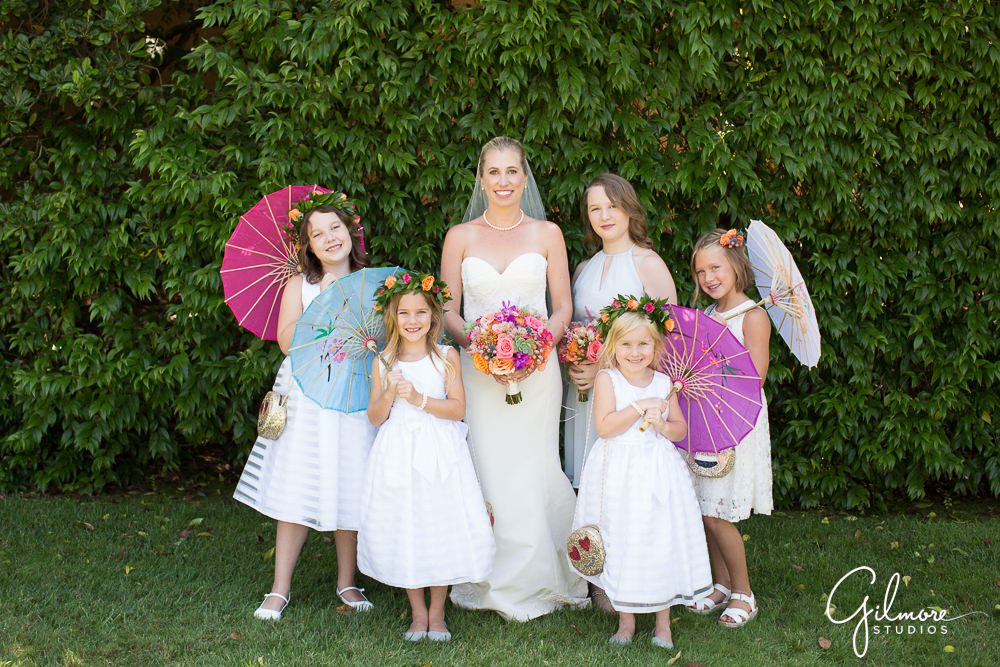 the bride gets a photo with her cute flower girls in Newport Beach