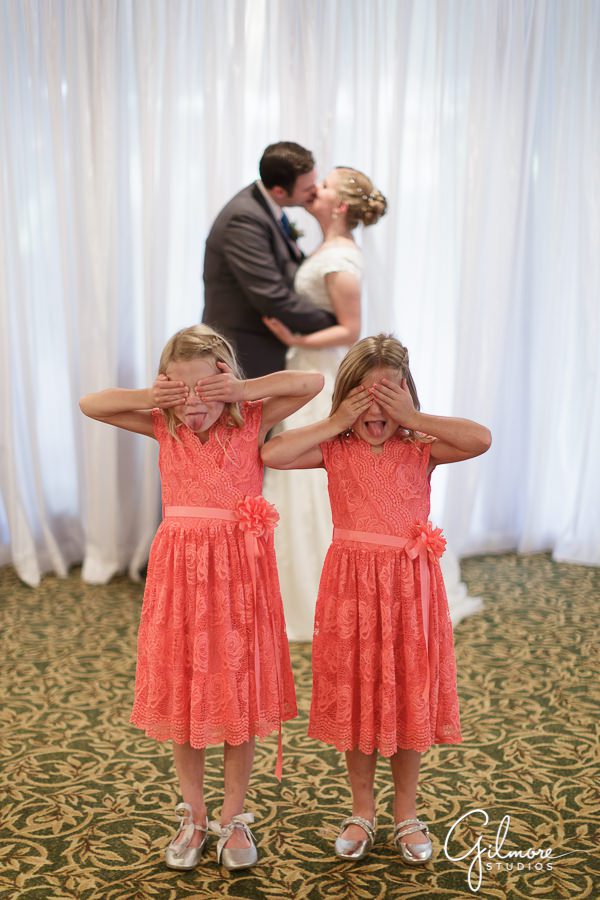 kids cover their faces while bride and groom kiss, Calamigos Equestrian Wedding