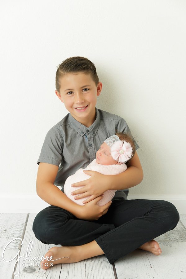 Newborn Family Portrait Photography, brother holds his new baby sister