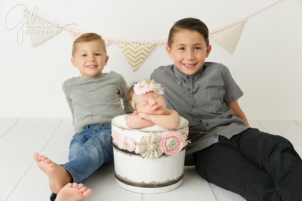 baby sister and her big brothers posing for a newborn session