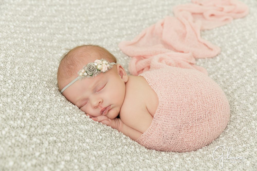 Orange County newborn portrait, pink baby wrap, headband, posed, props