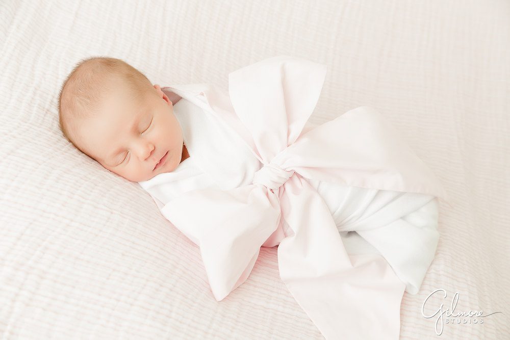 Maternity Newborn Photography, swaddled baby, pink ribbon, blanket background, girl, studio portrait session package, sleeping