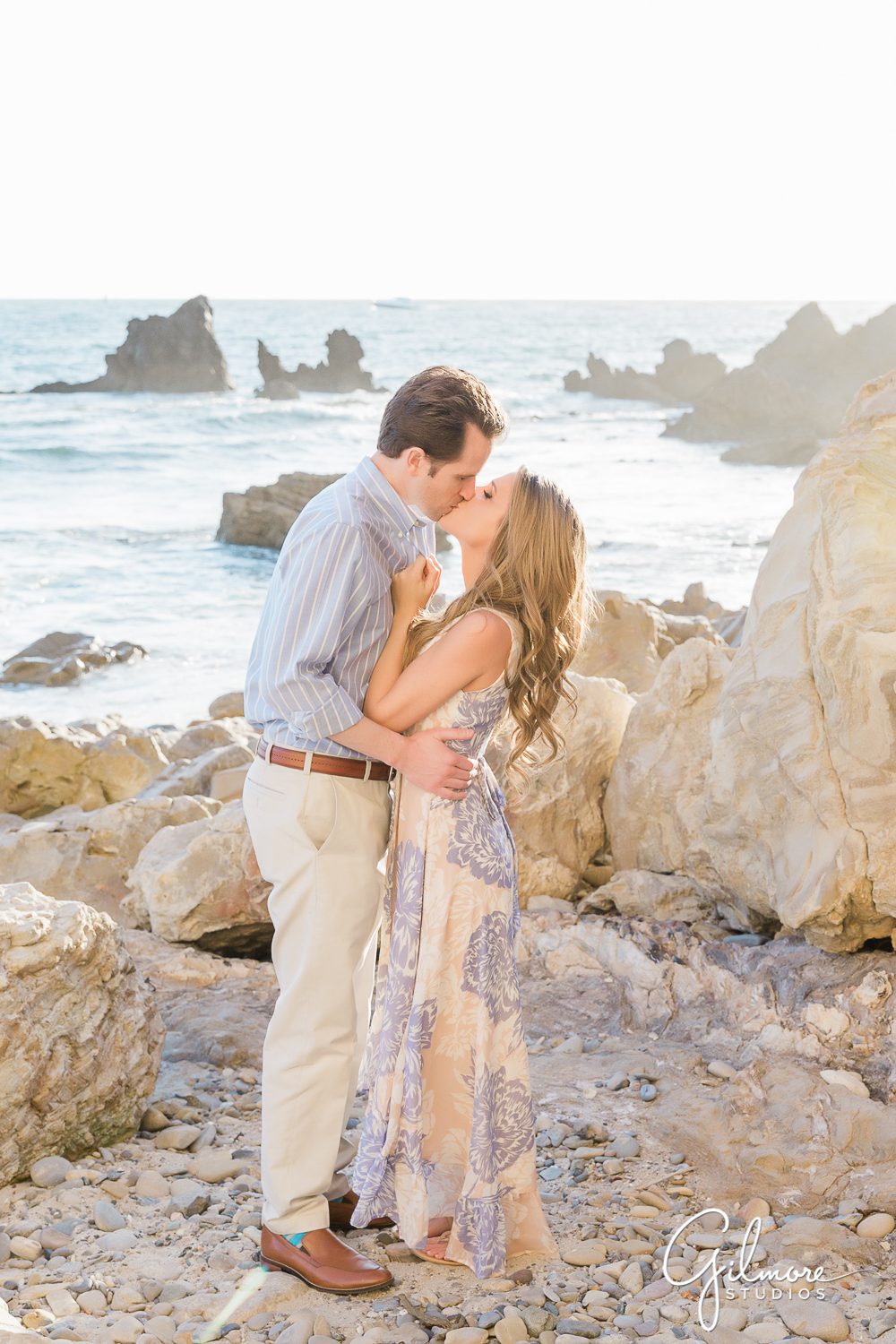 Newport Beach Engagement Session, engaged couple kissing, ocean, waves, rocks, sand, dress, portrait, natural light, sunset