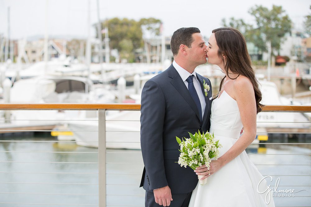 bride-groom-kiss-newport-harbor-yacht-club-wedding-portrait-newport-beach-wedding-photographers-gilmore-studios
