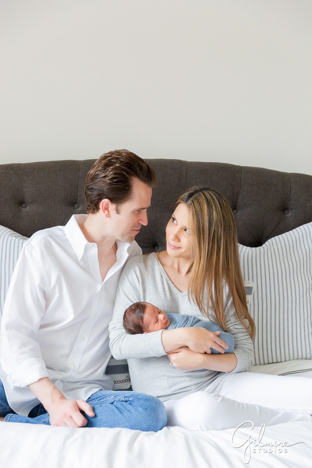 mom and dad holding newborn boy on the bed, Orange County Lifestyle Newborn Photographer