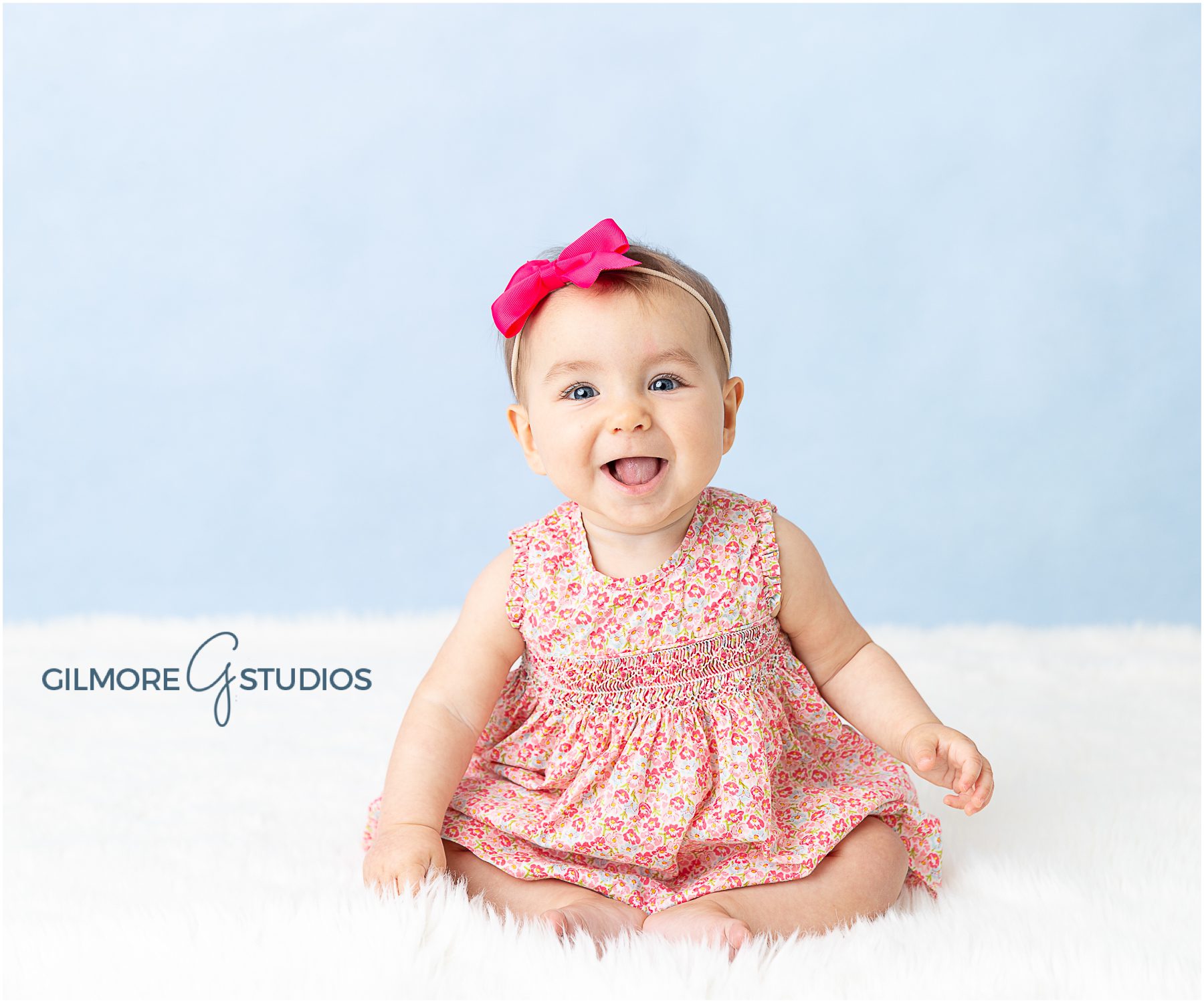 Newport Beach Children's Photography, blue background, sitting up, 6th months old, 6th month session, baby girl, baby prop, pink bow, floral dress, six months old