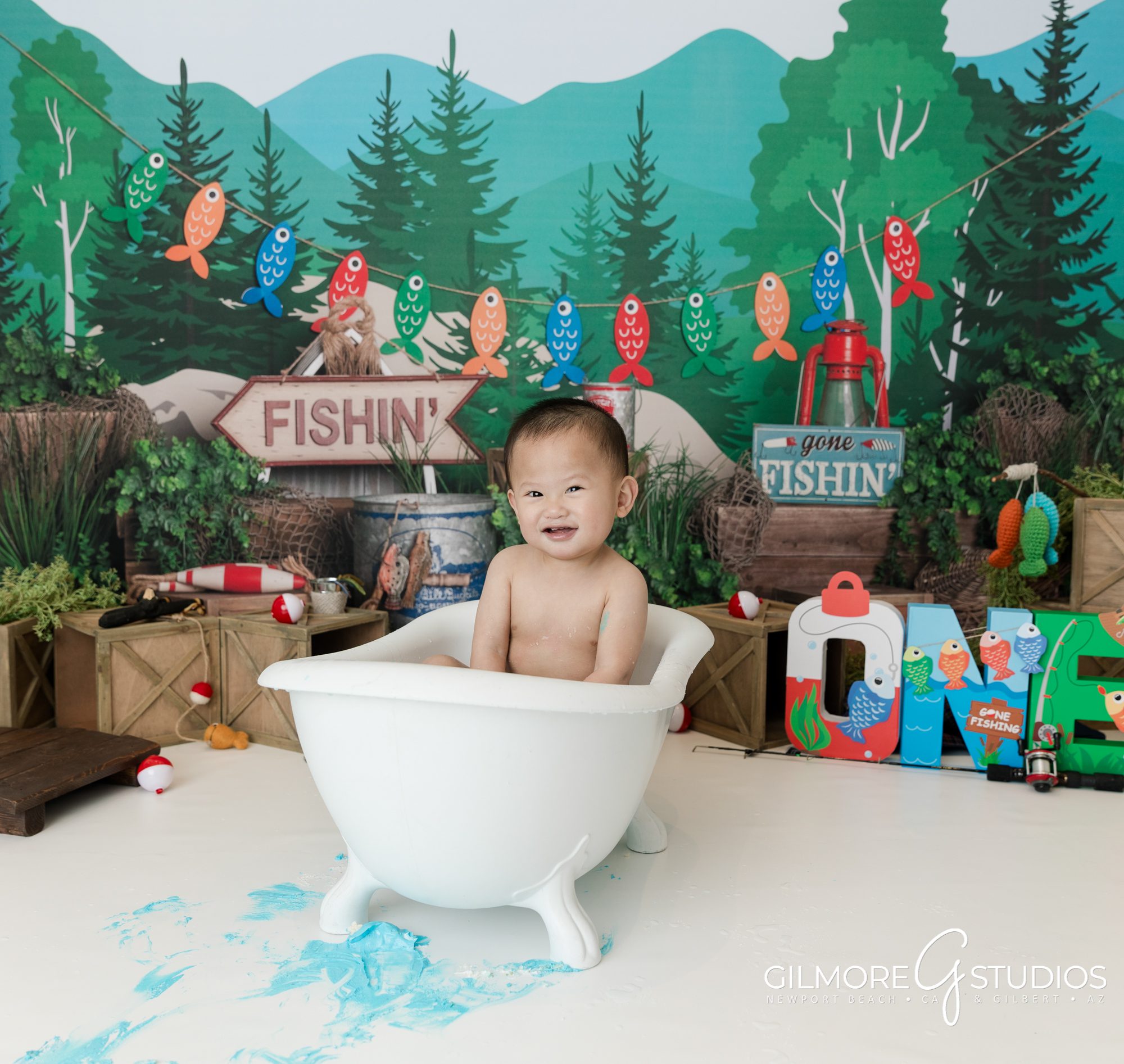 gilbert cake smash photography studio, 1st birthday, east valley kids photographer, gone fishin' first birthday photo session, fishing theme, one year old, cakes for boys birthday party, blue cake, bobbers, fishing pole, cute forest camping theme for boys, mini session, bath tub prop, kids photo props
