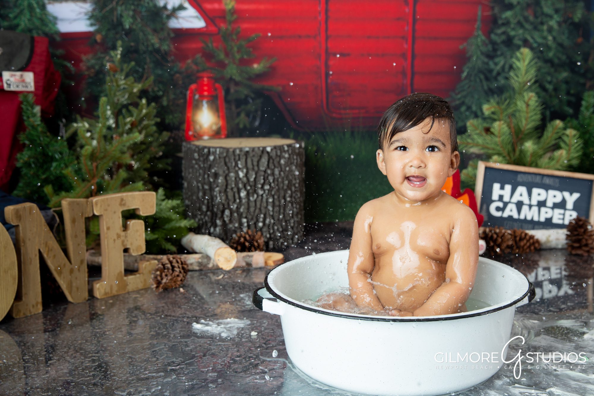 Camping themed cake smash by Gilmore Studios, camper, trailer, woods, forest, outdoors, camp fire, happy camper, pine trees, great outdoors, one year old, 1 year old, first birthday, photographer, background, set design, cakes, smashcake