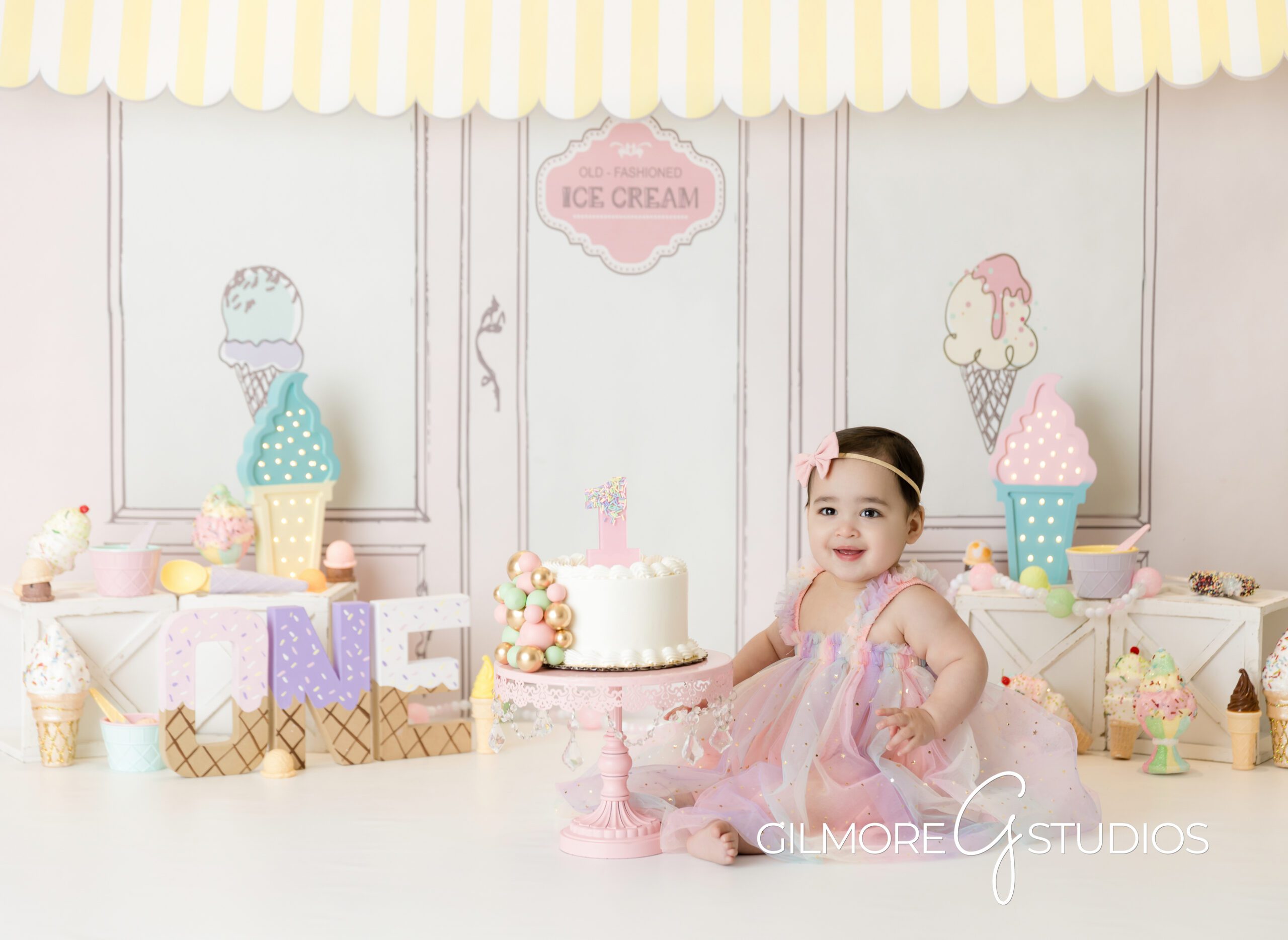 ice cream theme cake Smash, little girl, white cake, pink dress, pink bow, ice cream, ice cream parlor, photography, cake Smash, Gilmore Studios