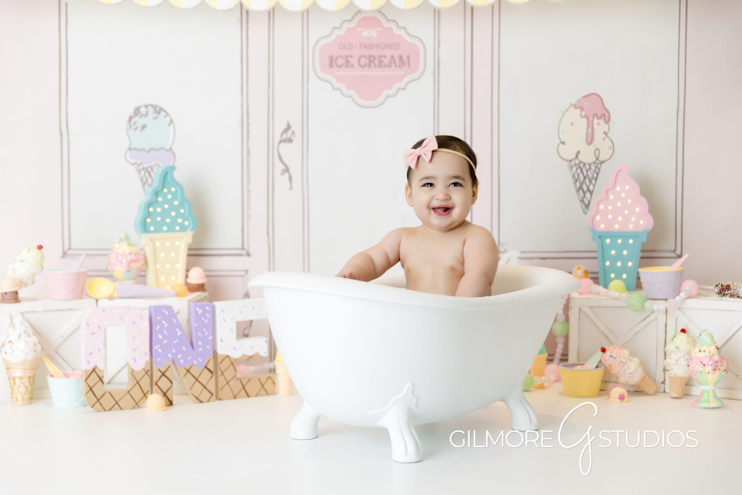 ice cream theme cake Smash, little girl, bathtub, ice cream parlor, pink bow, little girl smiling, photography, Gilmore Studios
