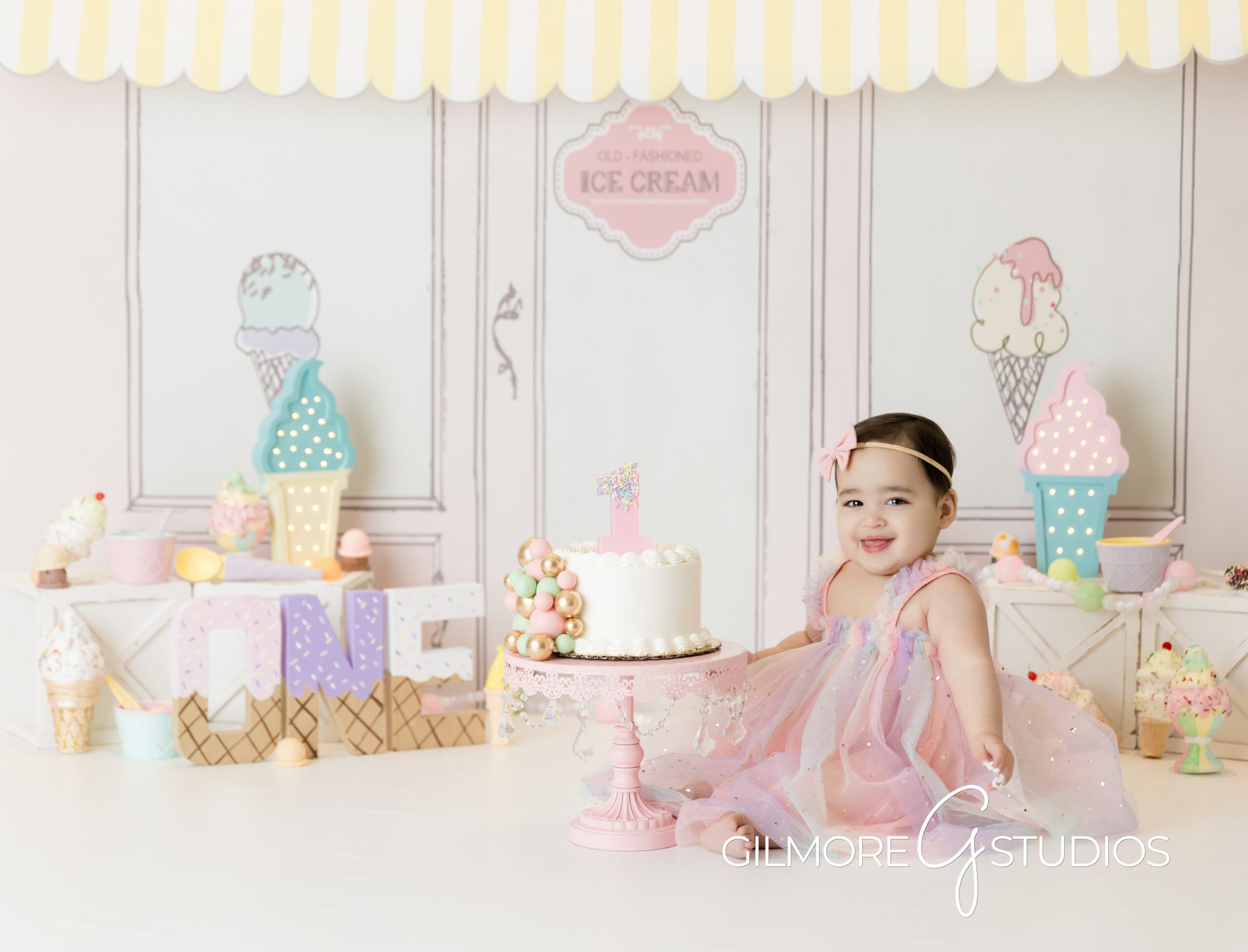 ice cream theme cake Smash, little girl, pink bow, pink dress, white cake, ice cream parlor, photography, Gilmore studios