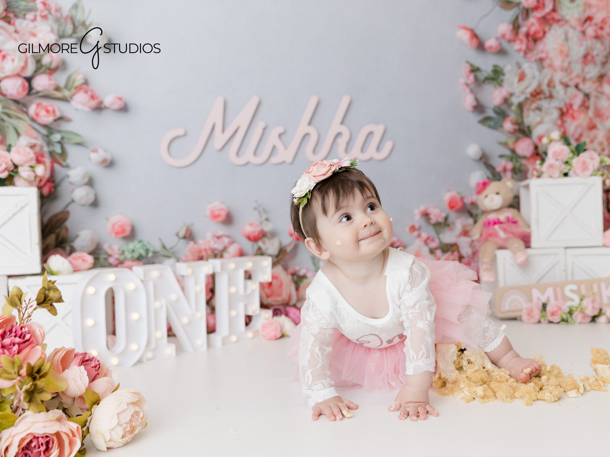 Close-up of baby with floral cake, Gilmore Studios birthday session