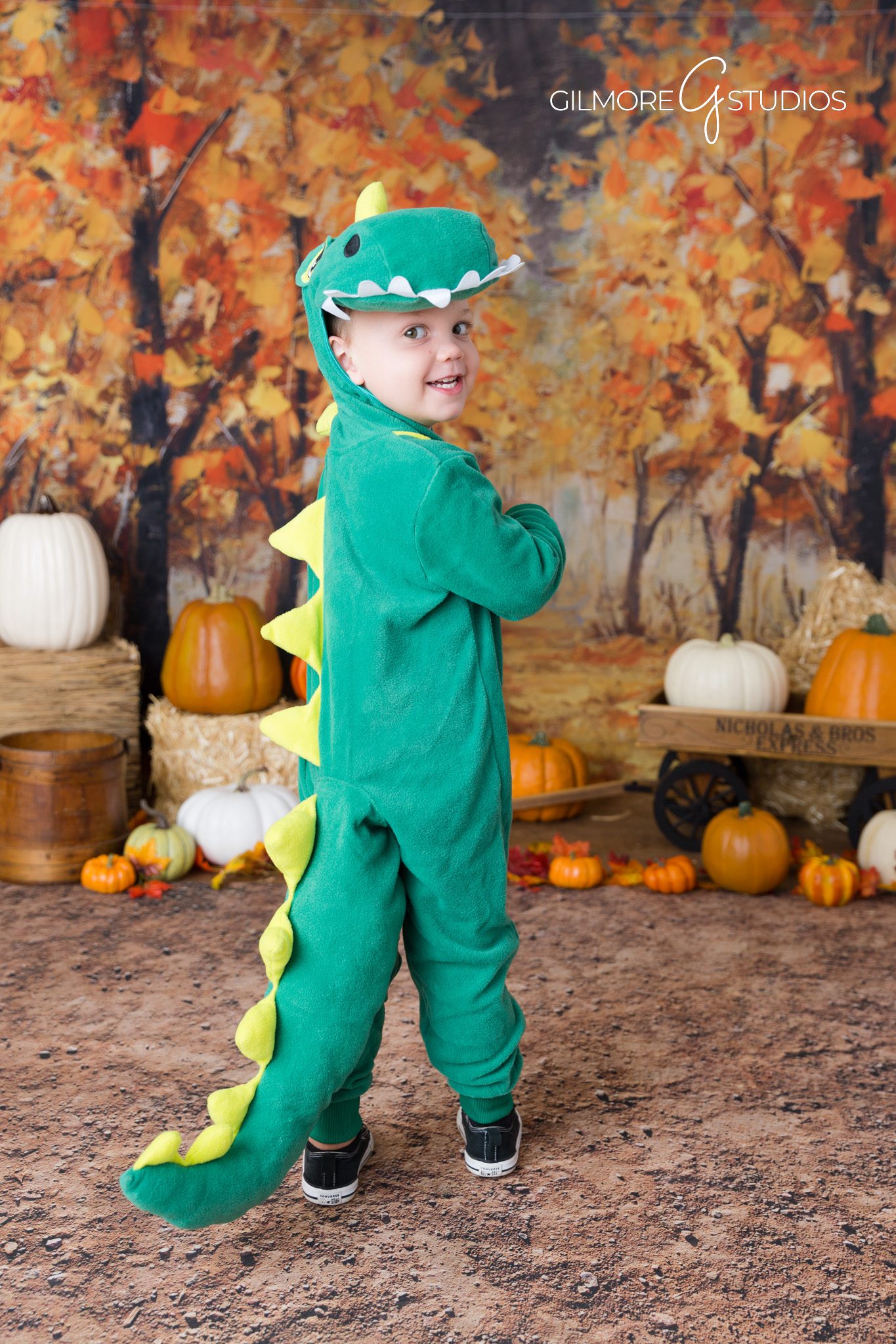 Child with fall props – pumpkin backdrop – cozy studio session