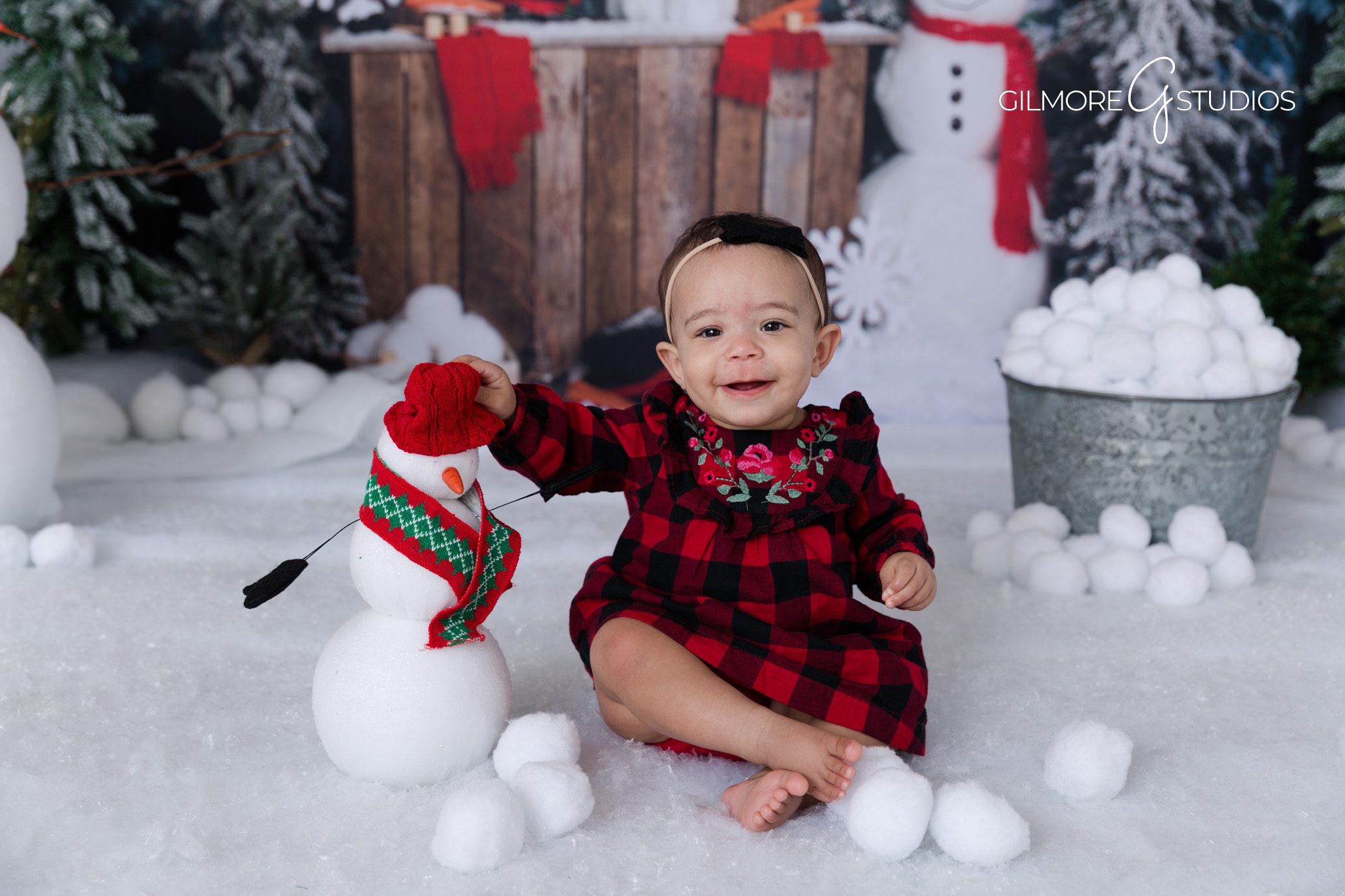 Baby smiling with snowman – winter studio portrait – Gilmore Studios