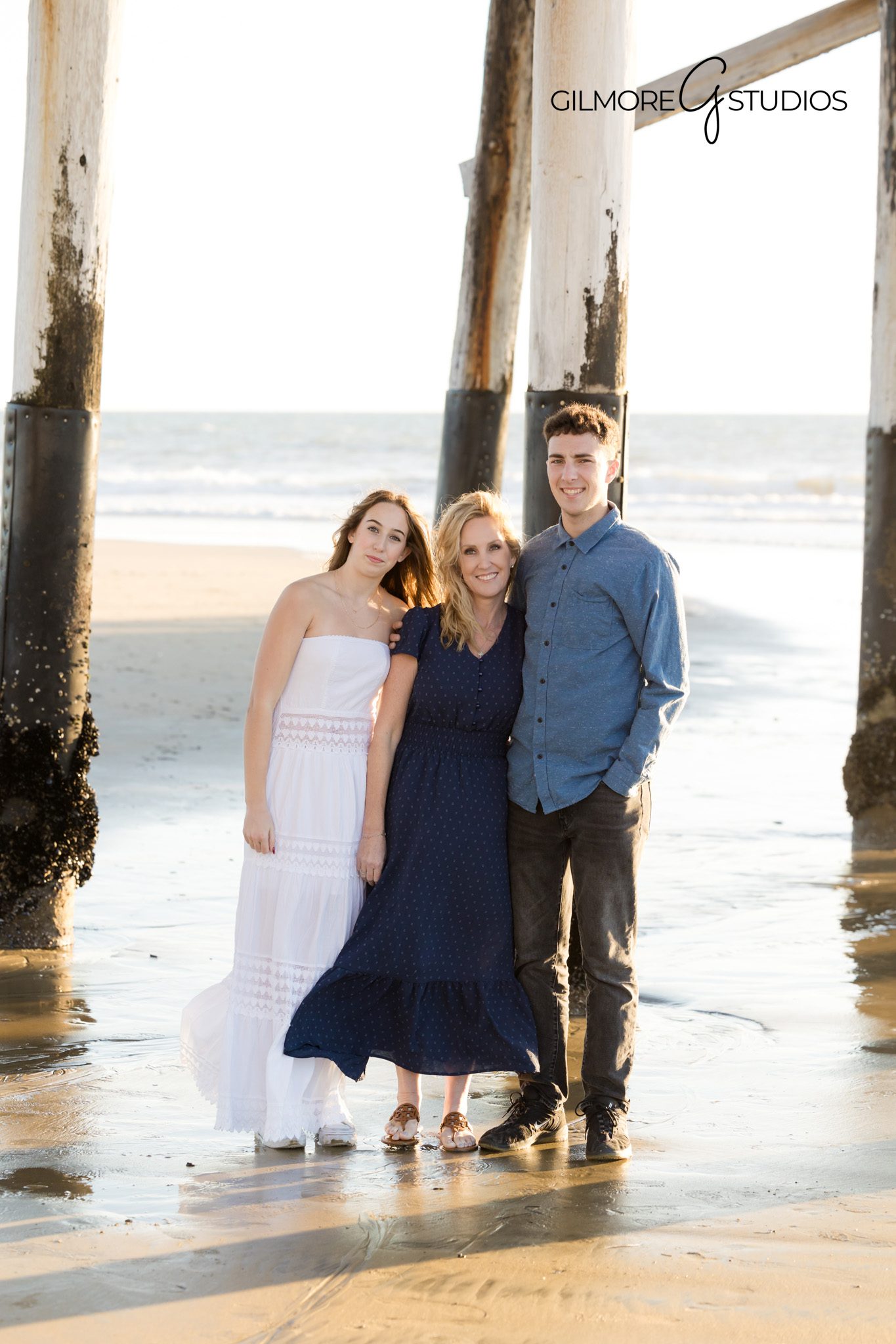 Waves crashing behind family photo at golden hour
