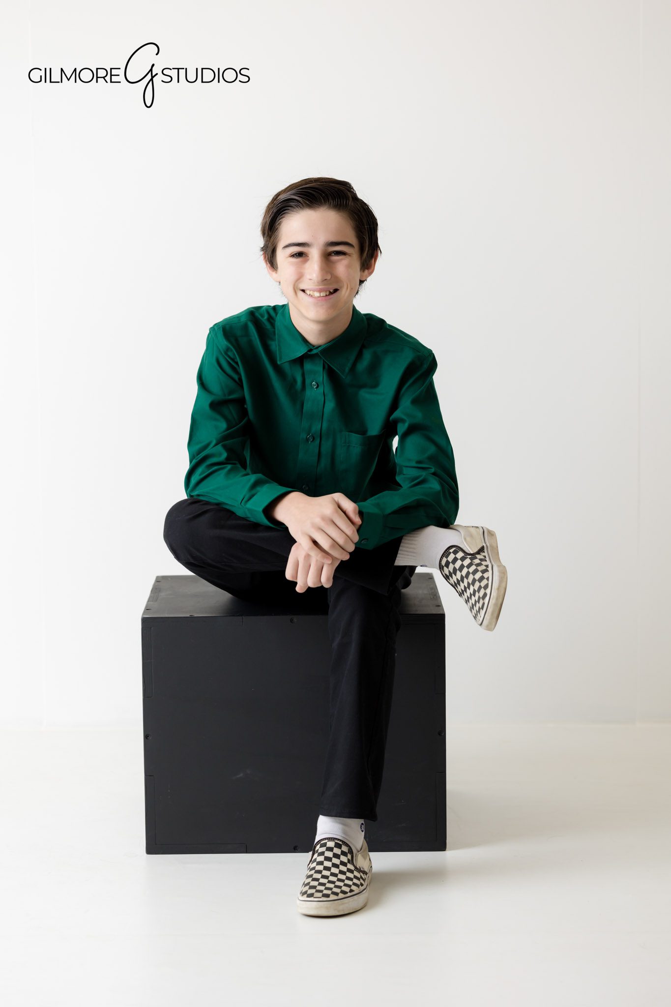 professional indoor portraits, family sitting on bench in studio, white floor and wall backdrop, calm and cozy photo session
