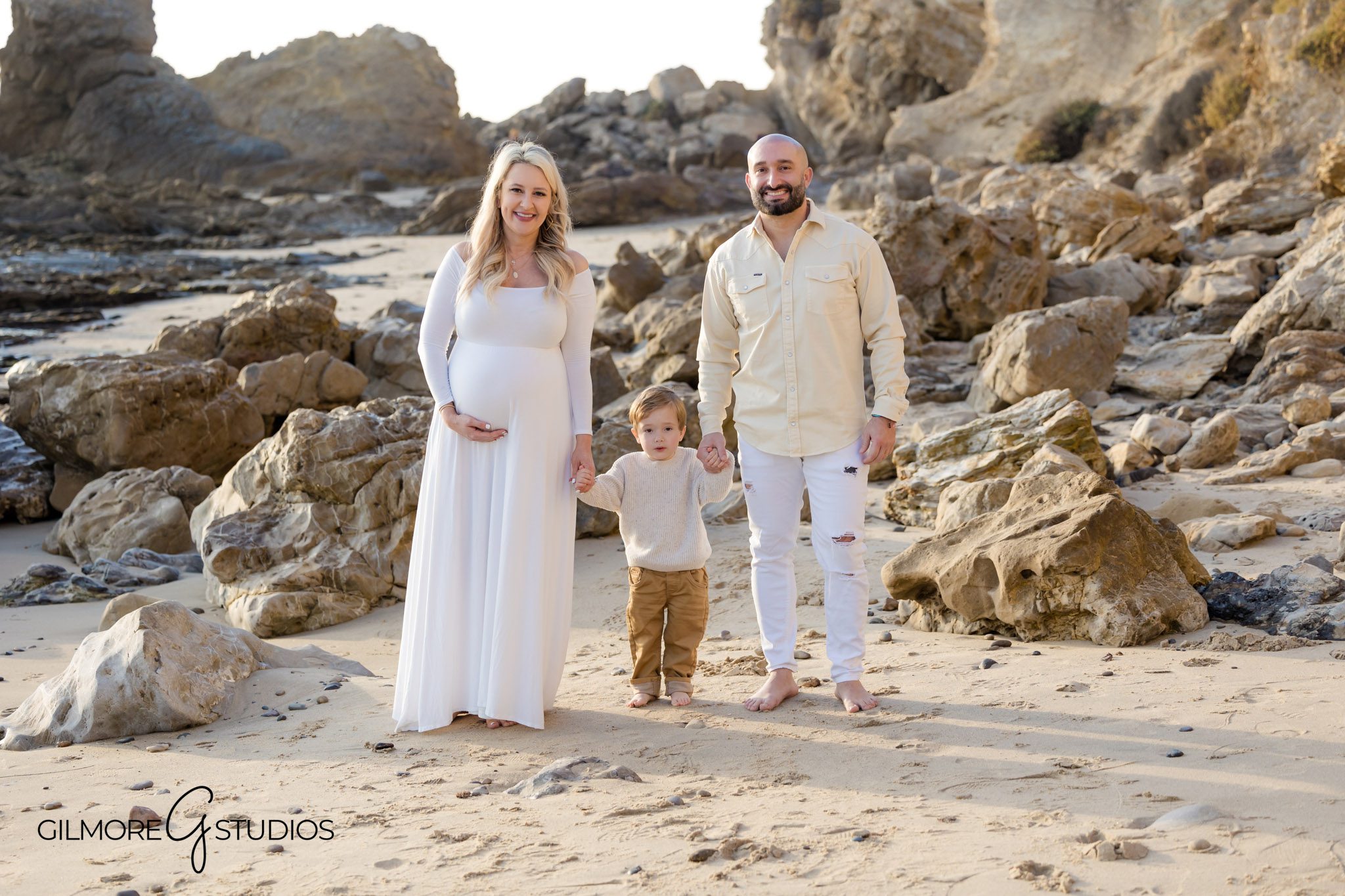 Artistic maternity photography by the rocks at Newport Beach, Gilmore Studios maternity portrait with beach waves