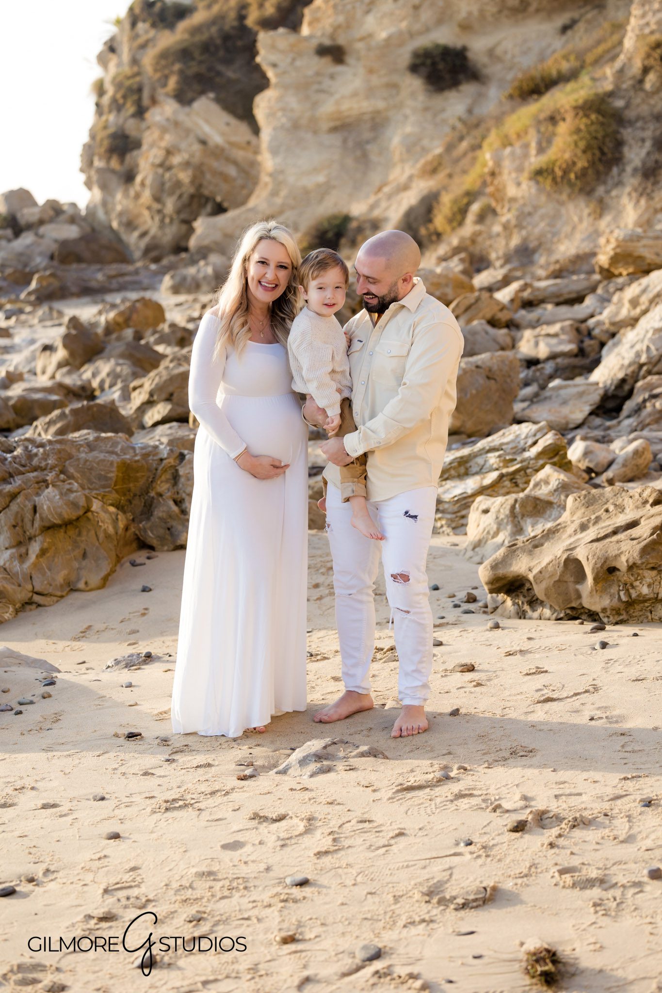 Expecting parents pose at Corona del Mar during photo session, Romantic maternity portraits by the sea