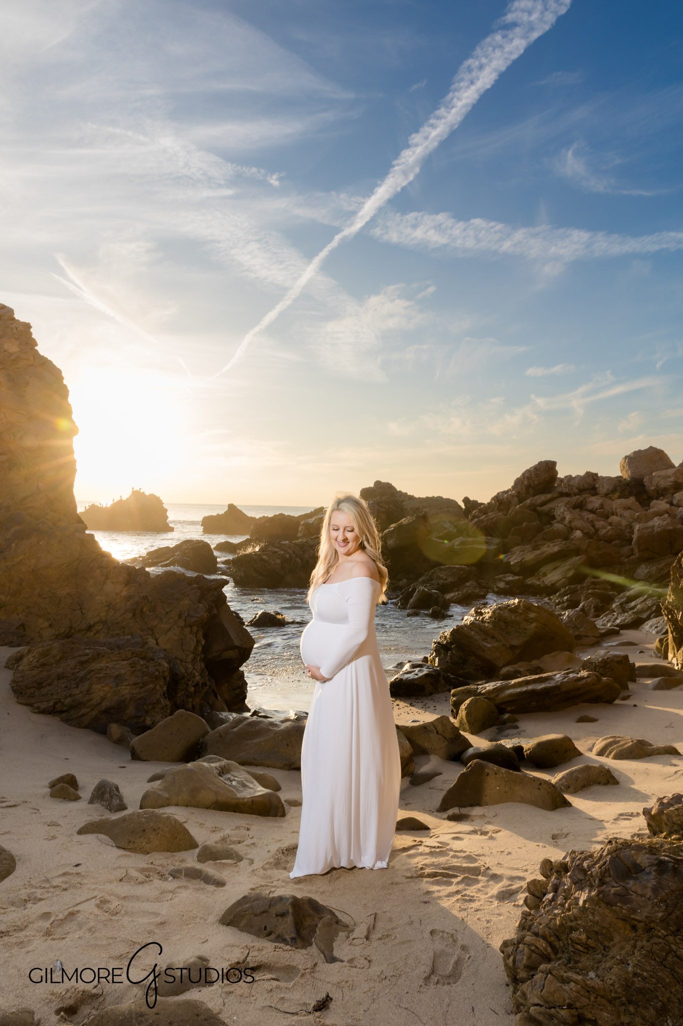 Portrait of pregnant woman on rocky California beach, Silhouette maternity photo at sunset on the beach