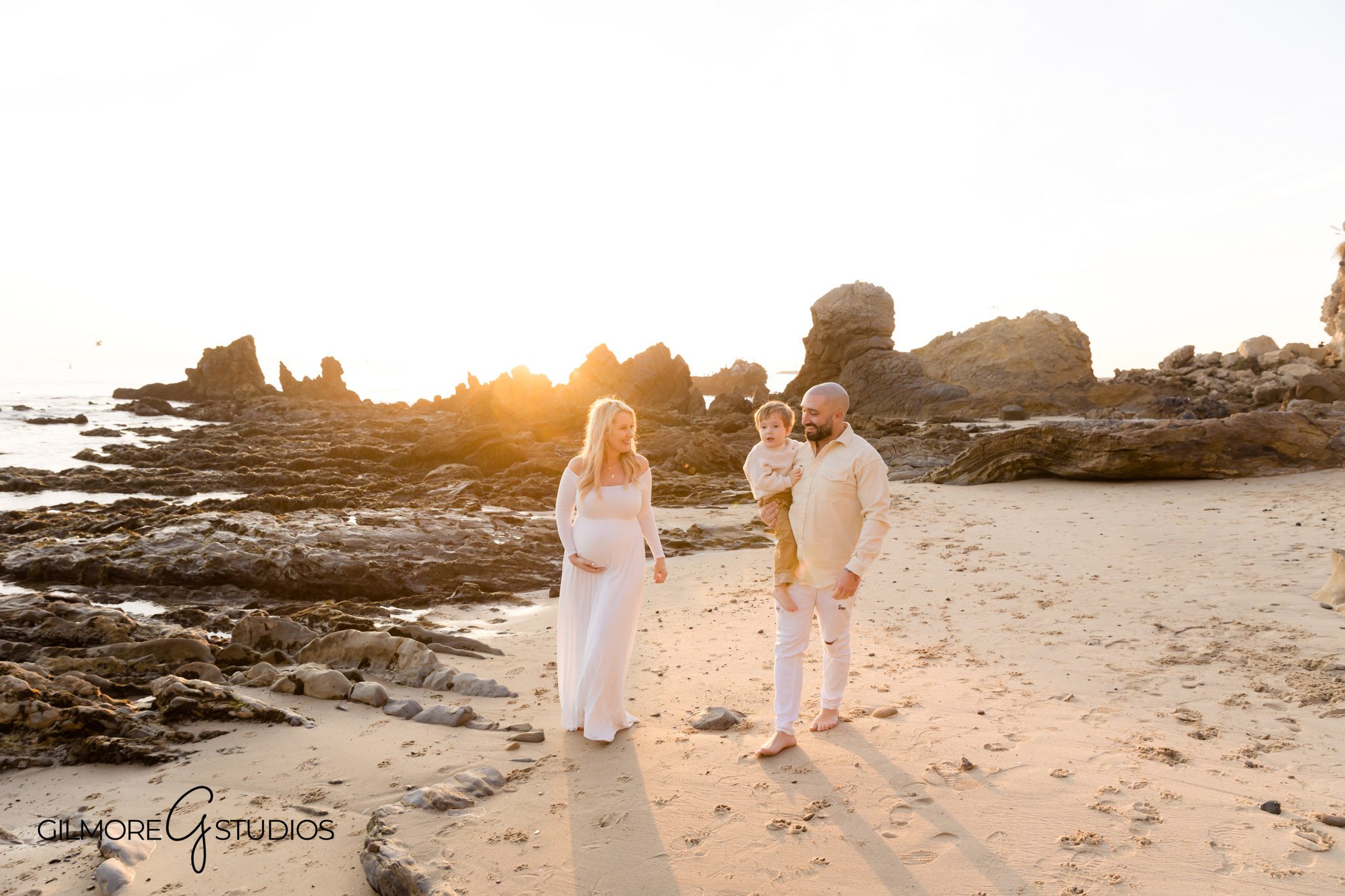 Flowing dress maternity session on rocky beach shore, Ocean view pregnancy photo shoot in Corona del Mar