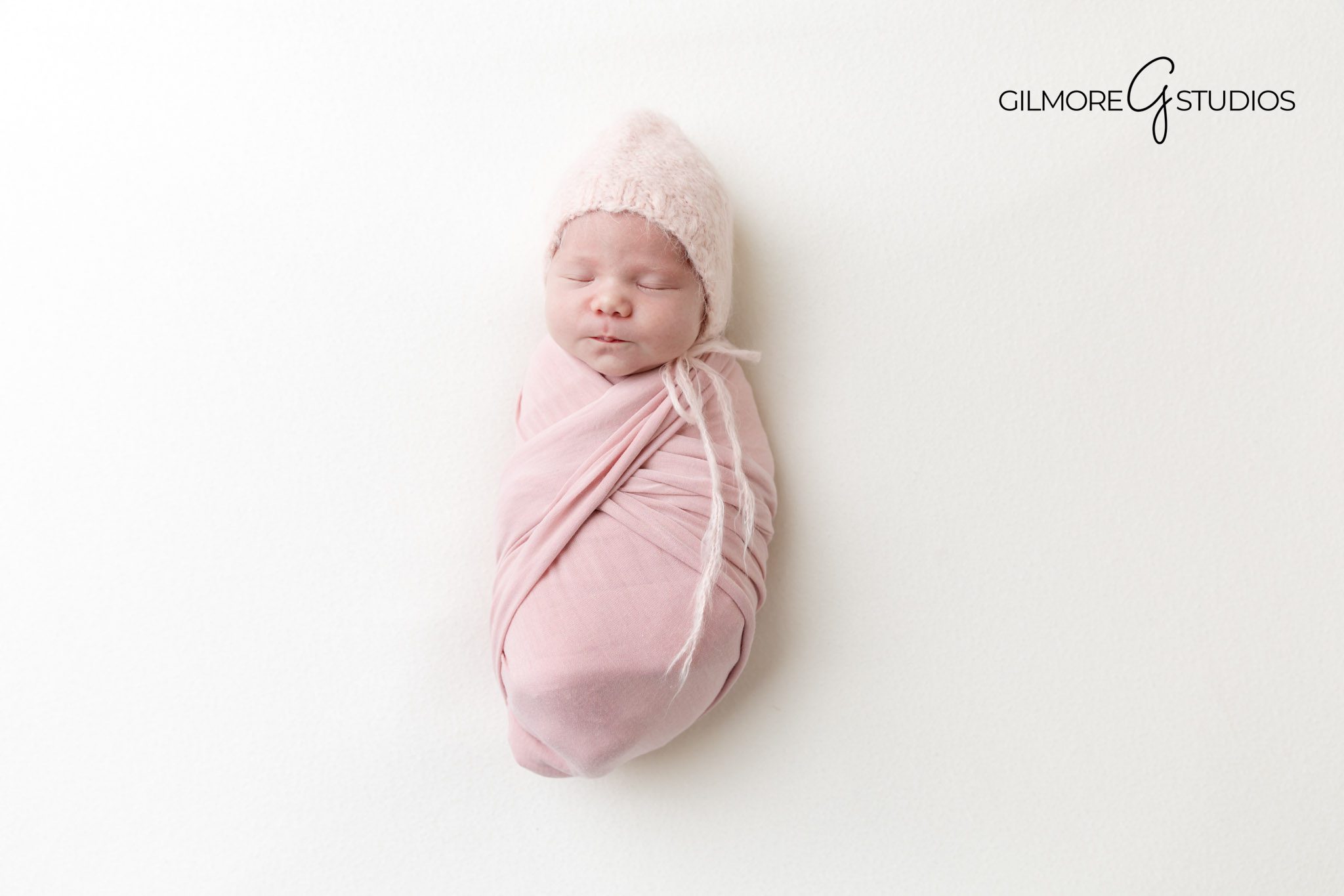 newborn photography session Newport Coast, indoor baby portraits Orange County, baby girl wrapped in white studio backdrop, classic newborn portrait photographer