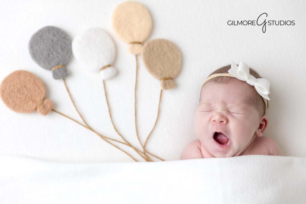 newborn girl photo with bow headband, baby photographer Newport Coast ideas, OC studio newborn photography image, baby posed on blanket in portrait studio