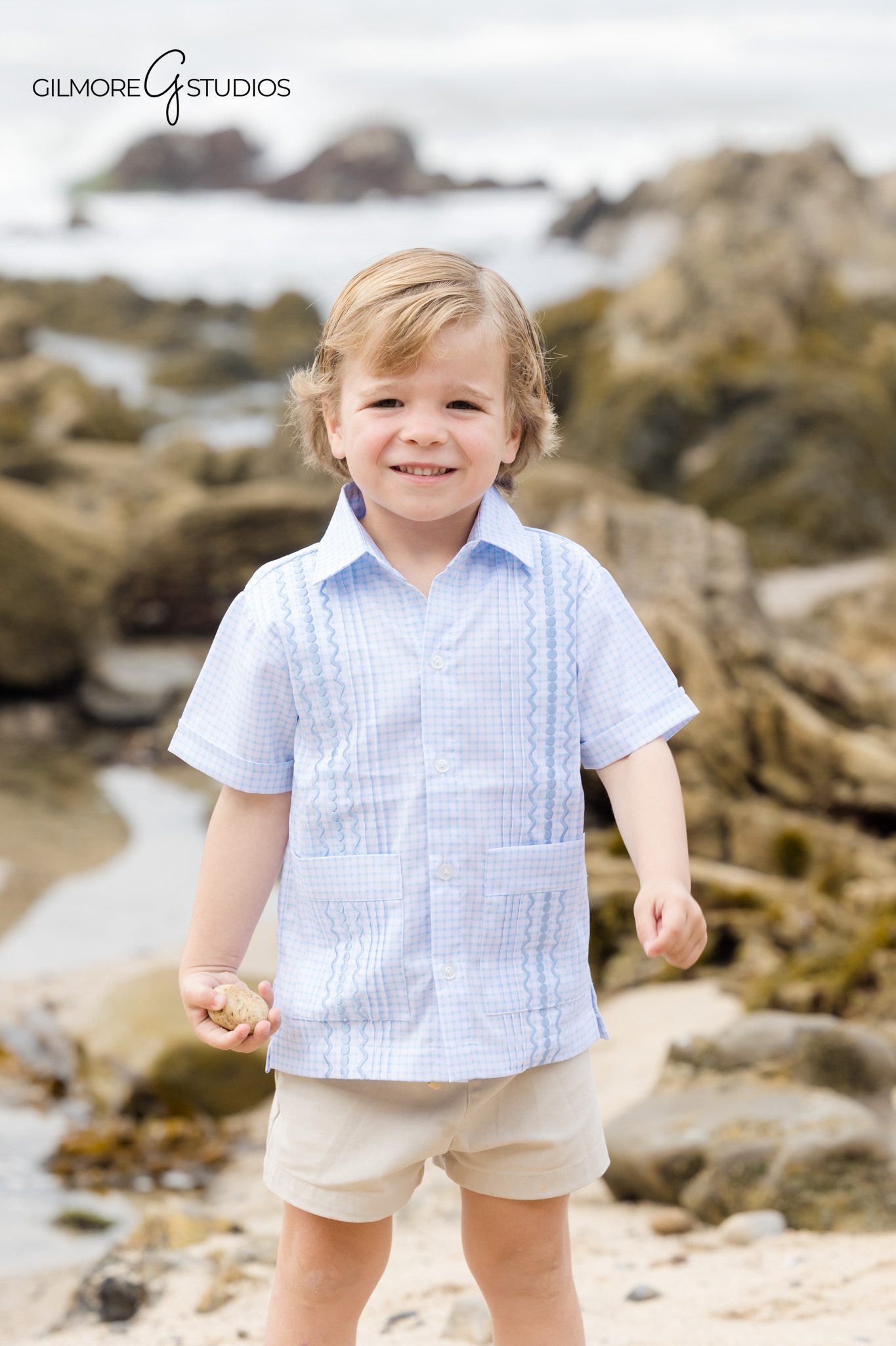 Holiday portrait photographer capturing parents cuddling with kids at shoreline.
Little Corona Beach family portrait with cliffs in background.