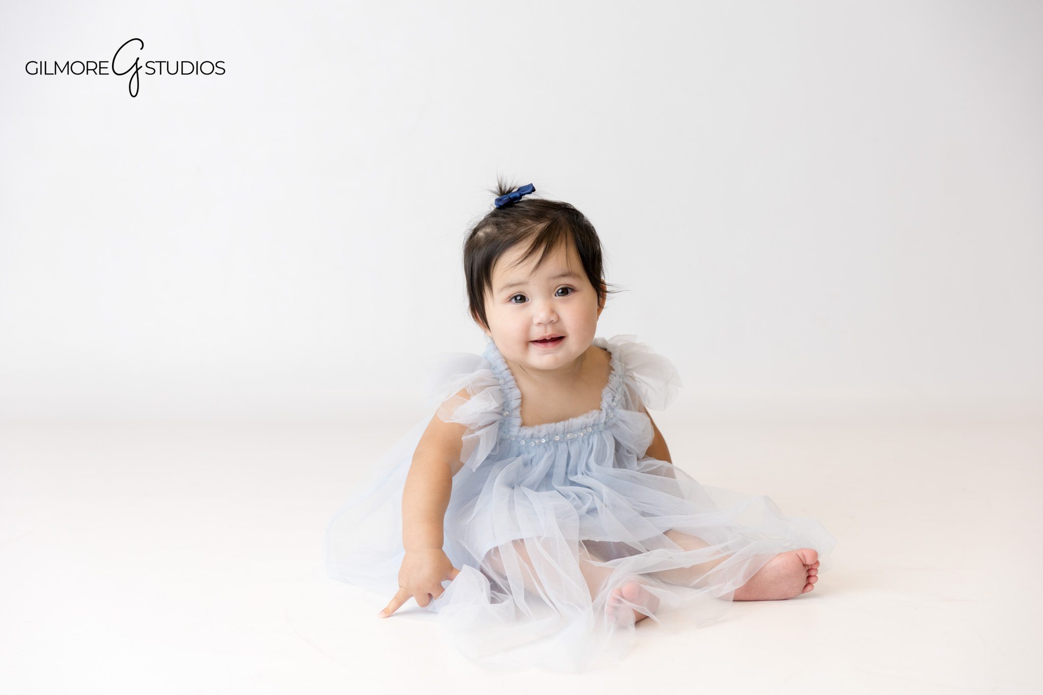 Mermaid birthday photoshoot with soft pastel background and ocean props.

One year portrait photography of baby girl in pearl headband and tutu.