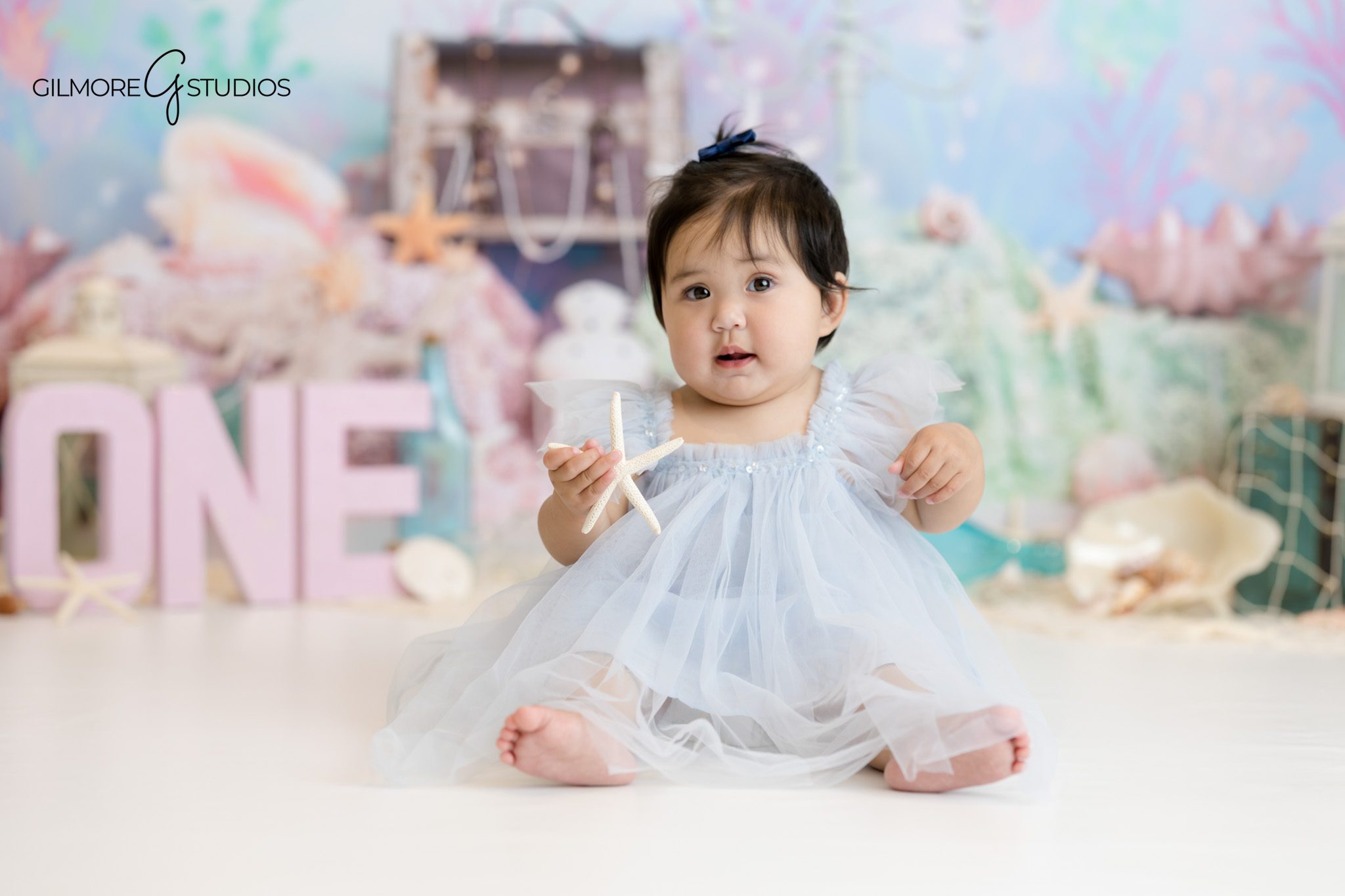 Mermaid cake smash photography for baby girl first birthday in Newport Beach studio.

One year milestone photographer capturing pastel mermaid theme cake smash.