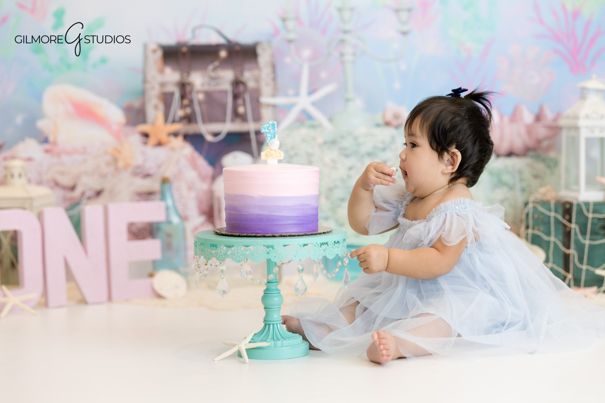 Newport Beach studio photography showing baby girl with mermaid tail props.

First birthday portrait photographer capturing joyful cake smash expressions.